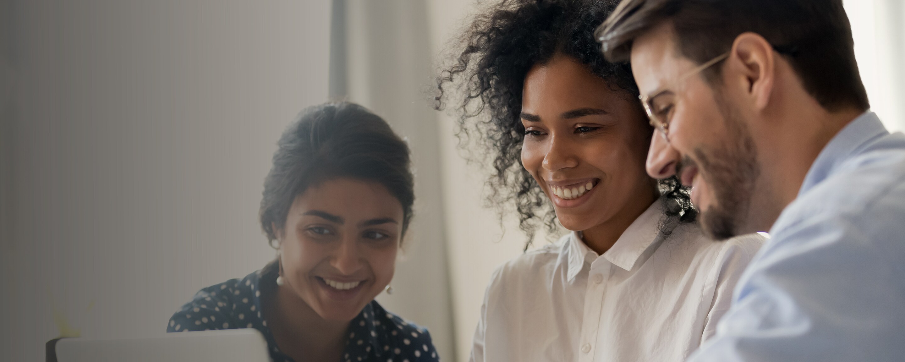 Three marketers smiling and reviewing work